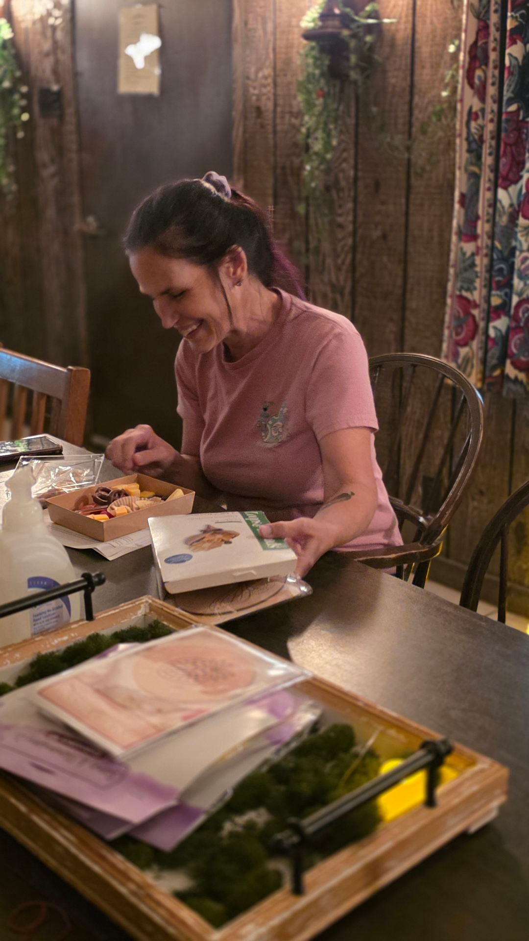 A guest smiling at a table with snacks and crafting supplies