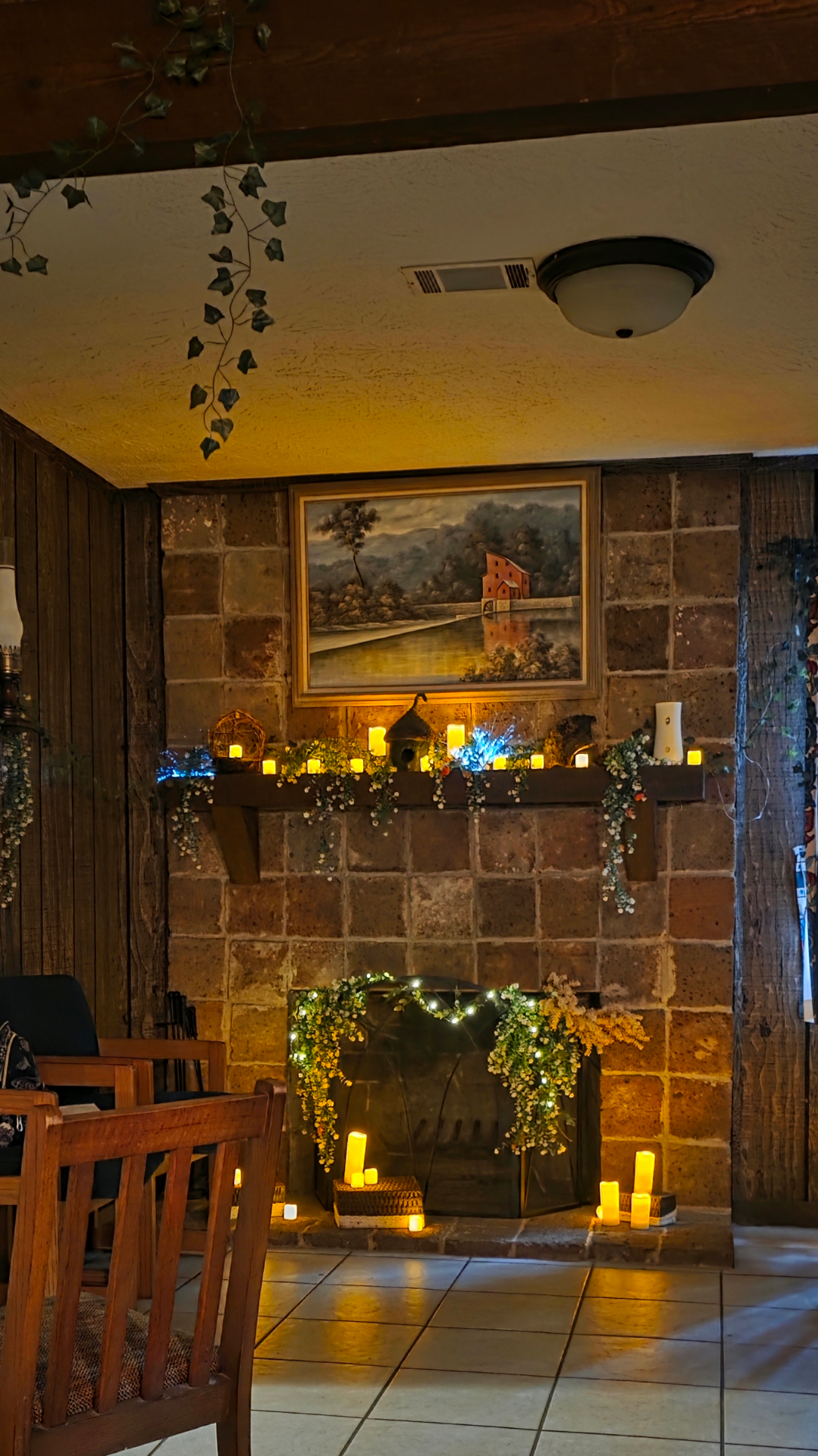 Stone fireplace decorated with greenery and candles