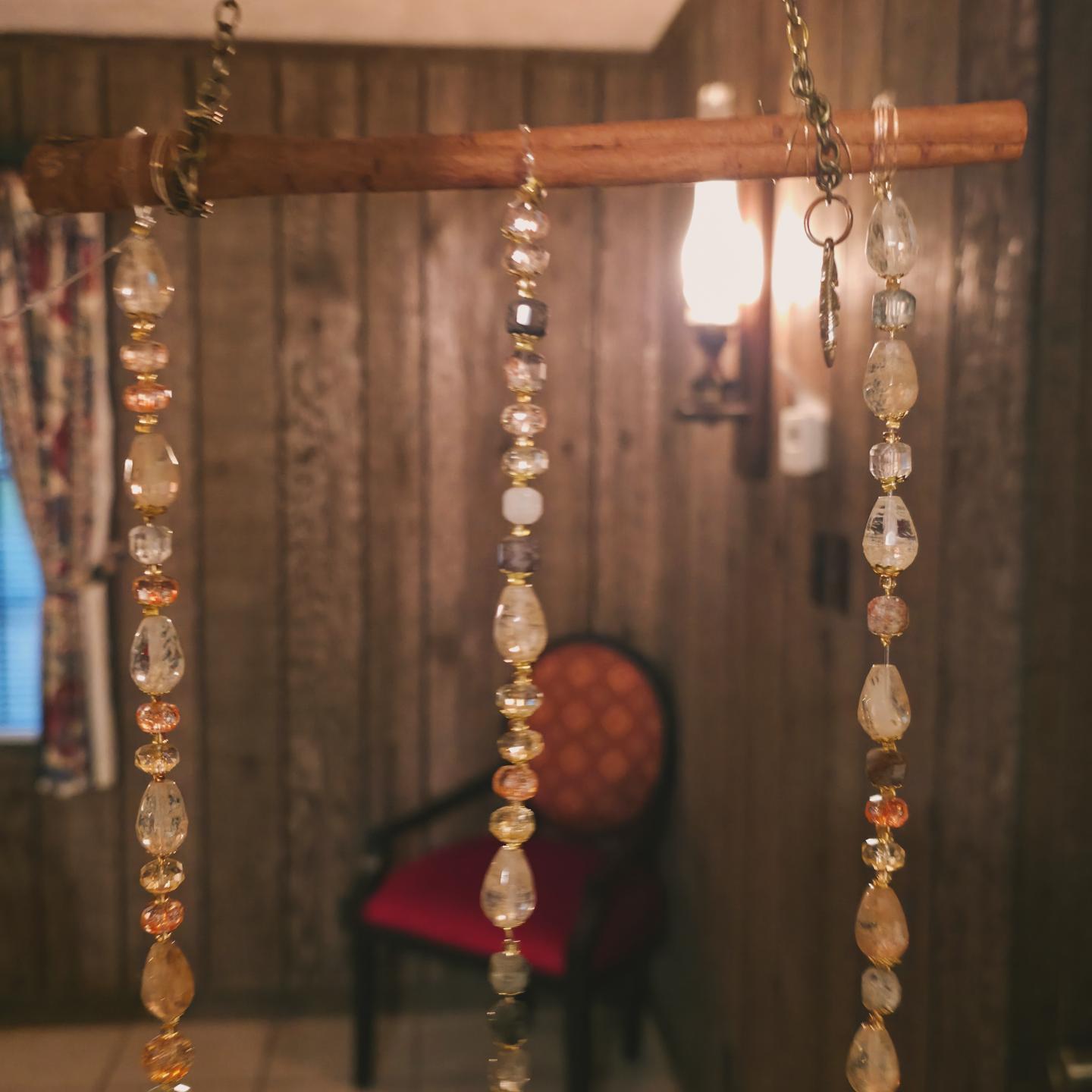 Beaded crystal strands hanging from a wooden branch