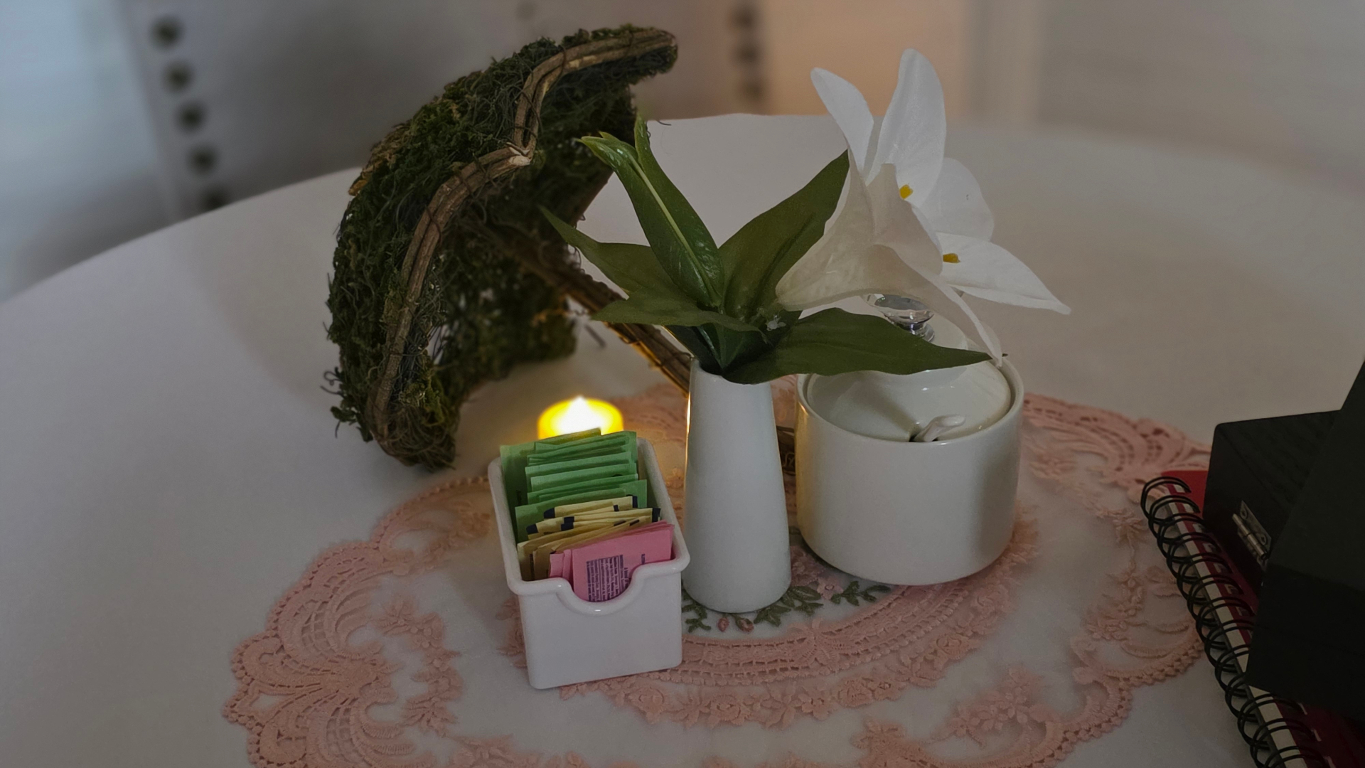 Tea tray with lily, sweeteners, and candlelight
