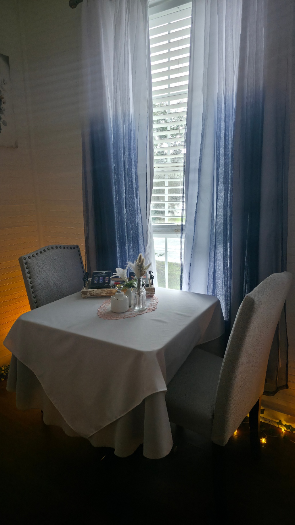 Crafting table by sheer blue curtains