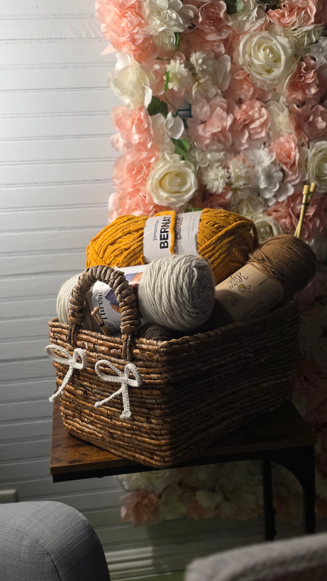 Basket of yarn set in front of a floral backdrop
